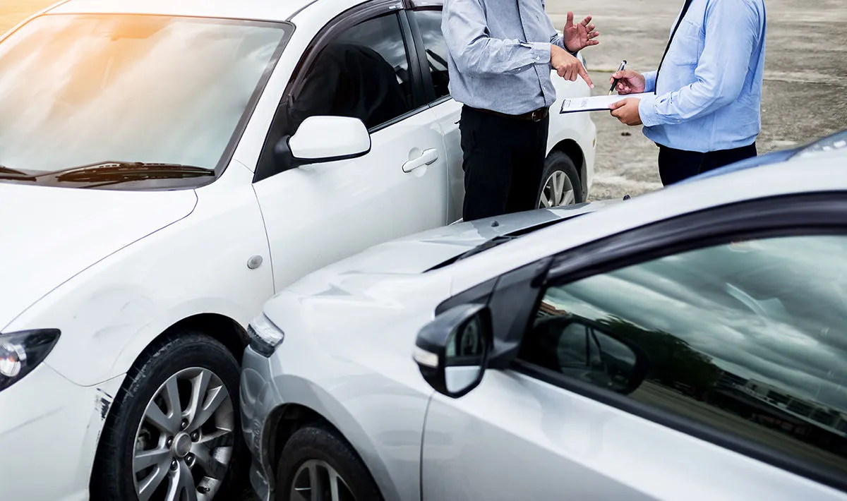 Two drivers assessing damage after a collision
