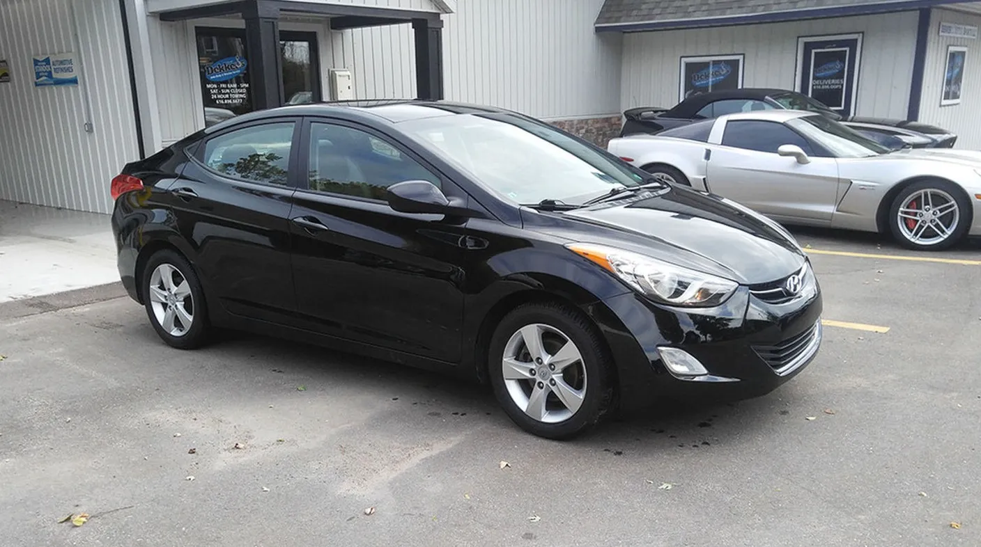 Repaired black Hyundai Elantra in the lot at Spanky's Collision Repair in Hudsonville, MI