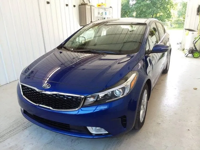 The same blue Kia Forte after repair at Spanky's, front end rebuilt and refinished