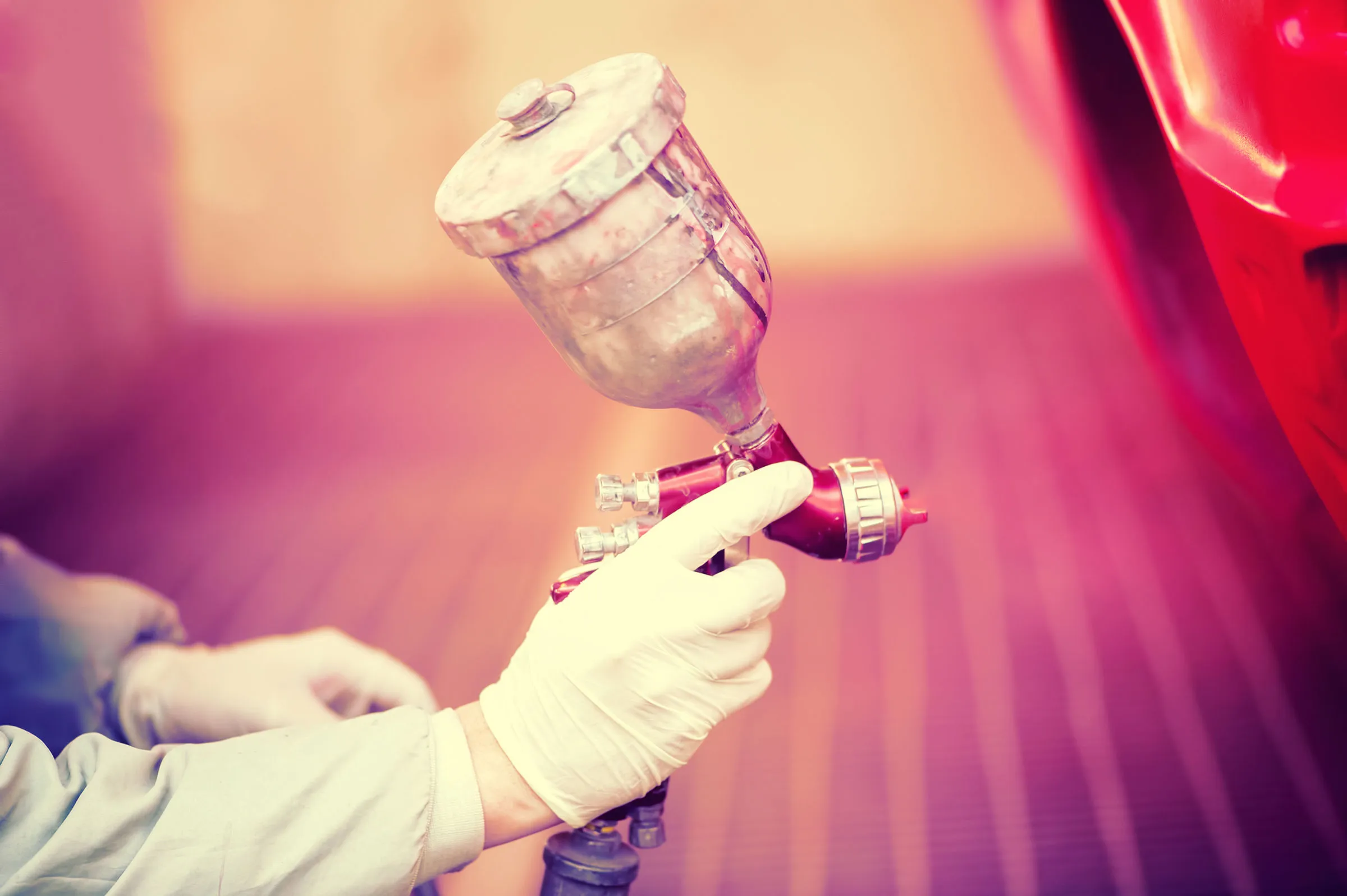 Spraying paint on a red panel